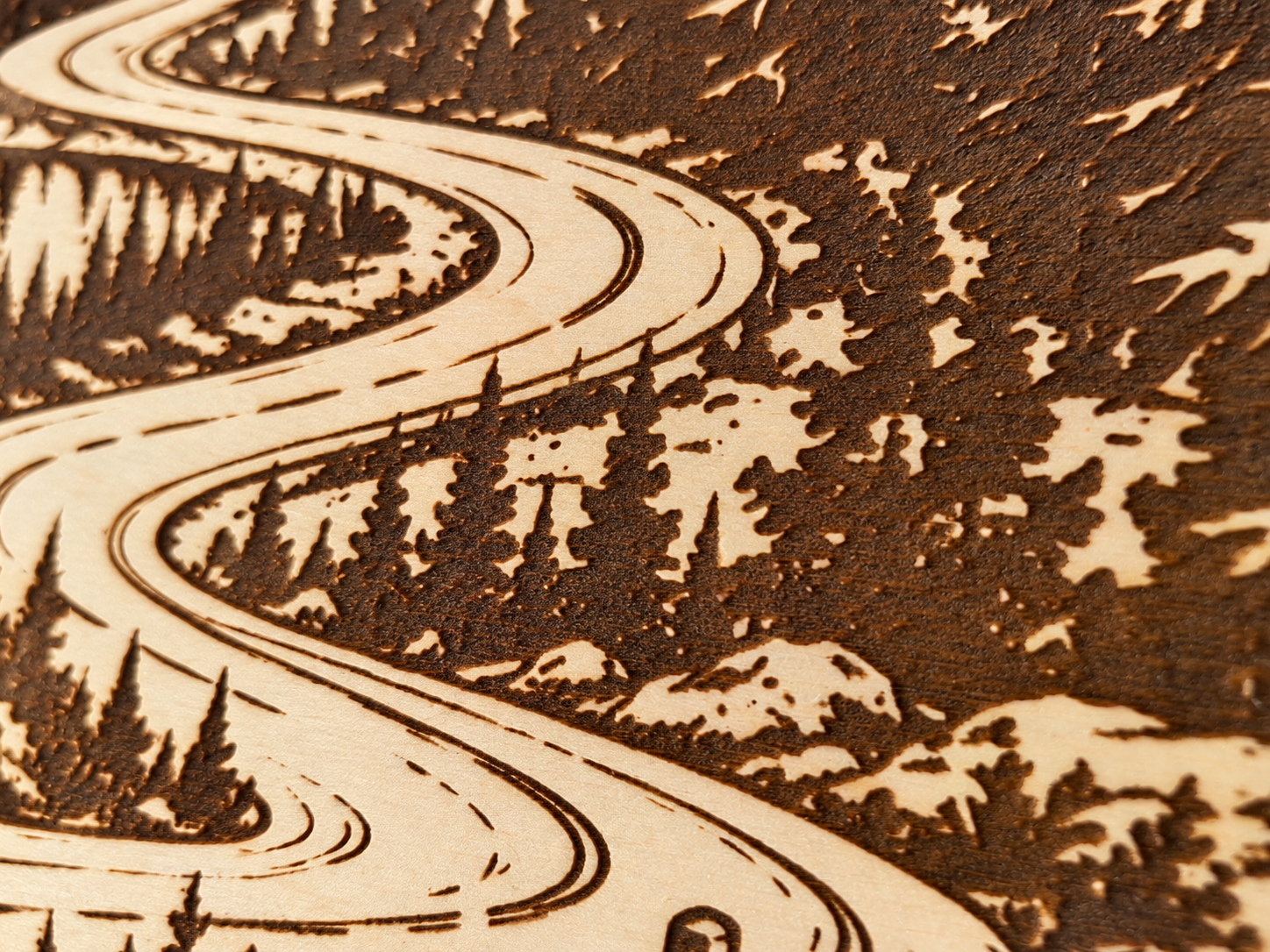 Detail der Holzgravur mit Weg und Bergen