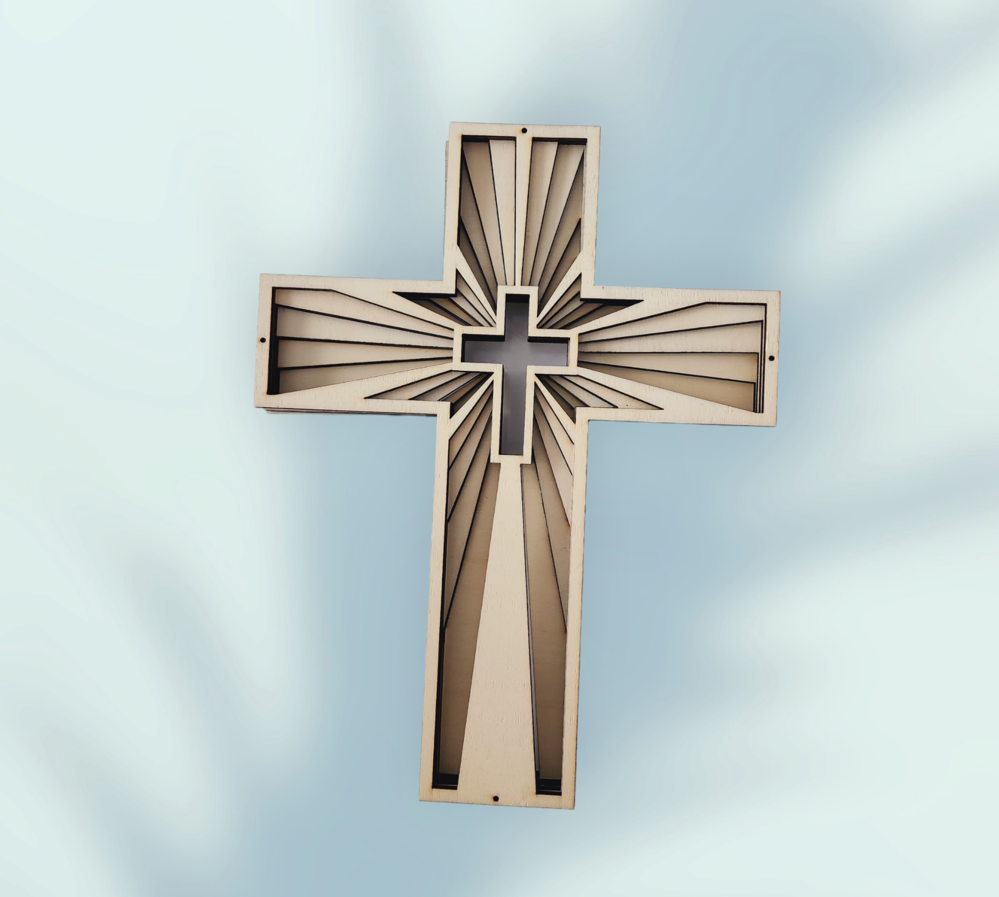 Dreidimensionales Holzkreuz aus sechs Schichten Sperrholz mit strahlenförmigem Relief und Kreuzmotiv in der Mitte
