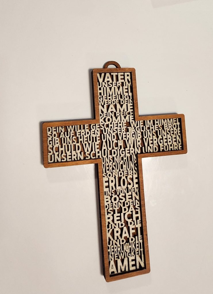 Holzkreuz mit ausgeschnittenem deutschem Vaterunser-Text, dunkler Rückseite, braunem Rahmen und Aufhängeöse